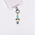 Product photo showing Blue character-inspired phone charm with colorful crystal accents and silver-tone phone hardware.