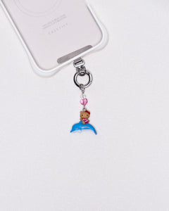 Product photo showing Vintage dolphin character-inspired phone charm with a blue crystal heart and silver-tone phone hardware.