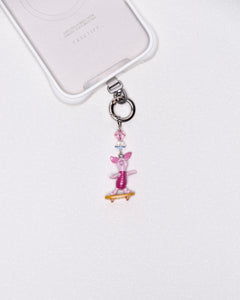 Product photo showing Vintage pink skateboard character-inspired phone charm with pink and blue crystal accents and silver-tone phone hardware.