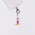 Product photo showing Vintage pink skateboard character-inspired phone charm with pink and blue crystal accents and silver-tone phone hardware.