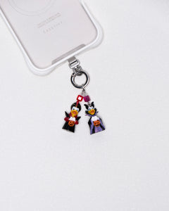 Product photo showing Vintage Halloween character-inspired phone charm with colorful figures, crystal accents, and silver-tone phone hardware.