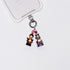 Product photo showing Vintage Halloween character-inspired phone charm with colorful figures, crystal accents, and silver-tone phone hardware.
