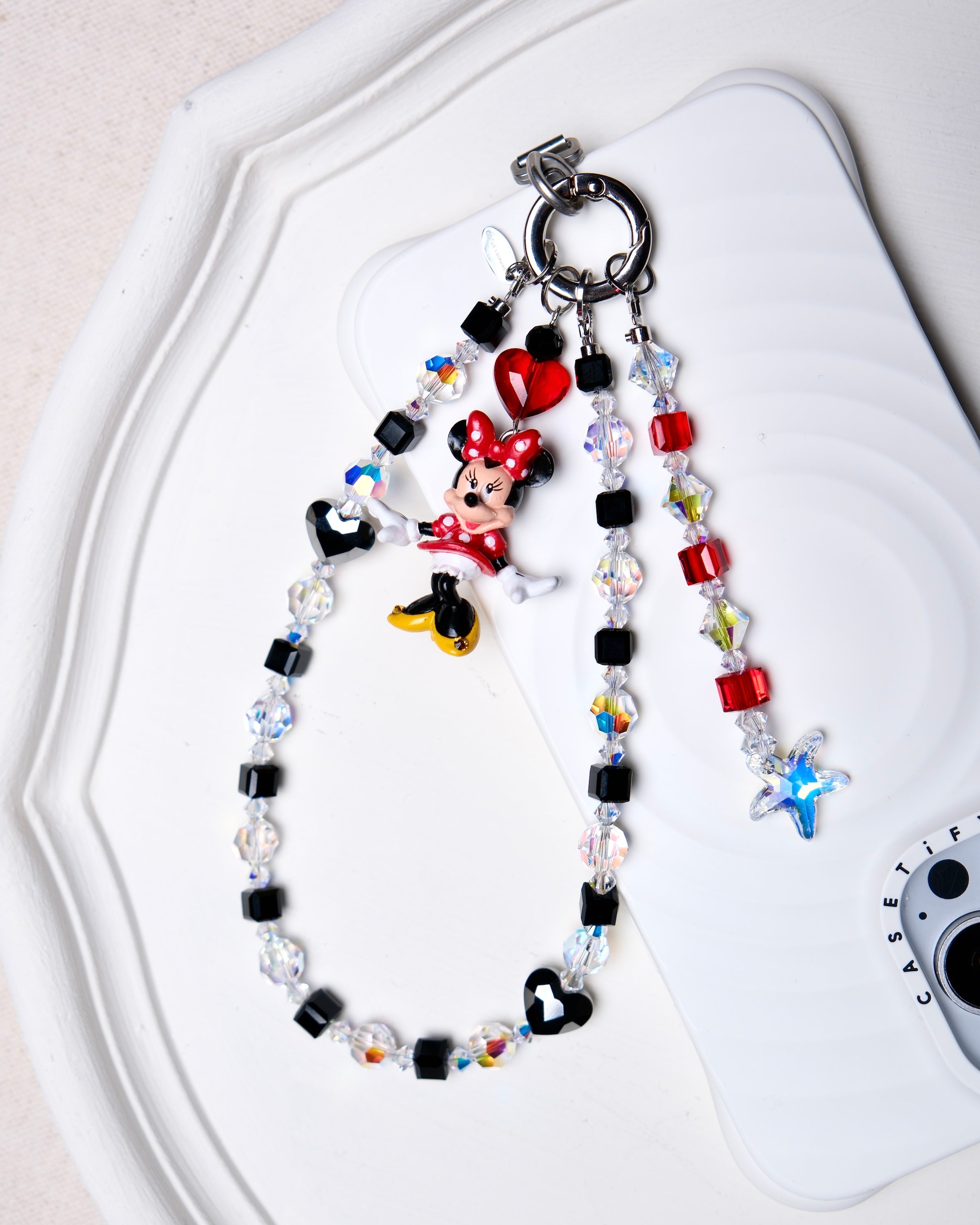 Detail product photo of a black Swarovski crystal phone chain with clear and iridescent crystal details.