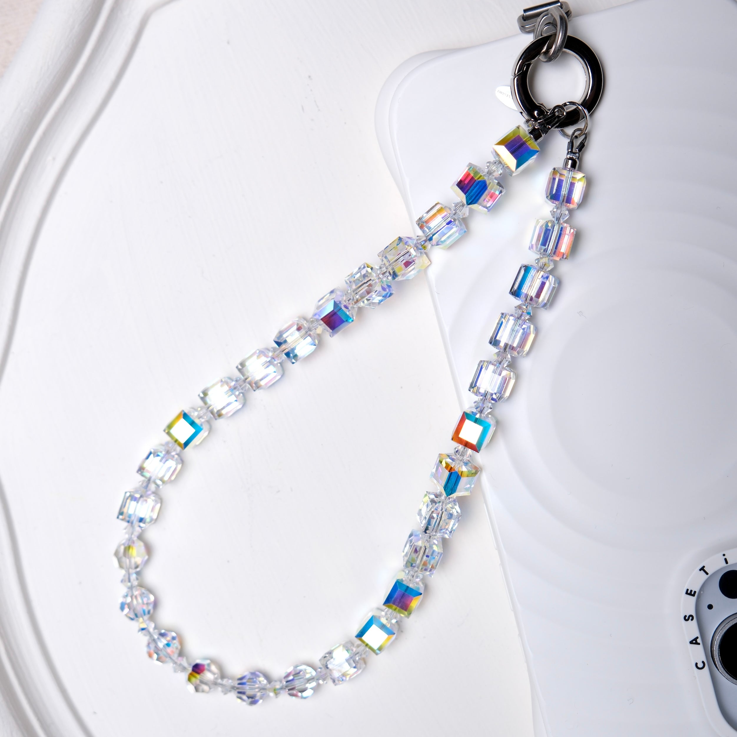 Aurora Borealis Swarovski crystal phone chain with silver-tone phone tab on a white tray