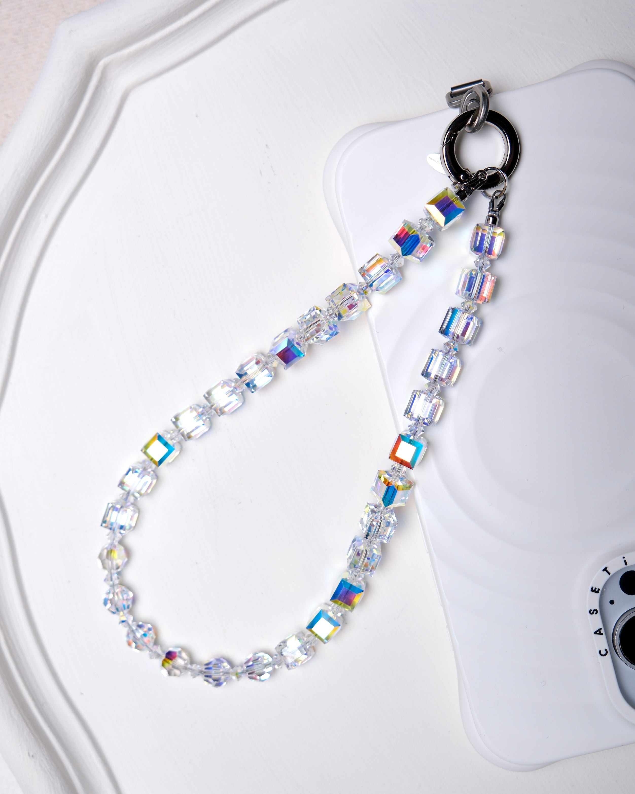 Aurora Borealis Swarovski crystal phone chain with silver-tone phone tab on a white tray