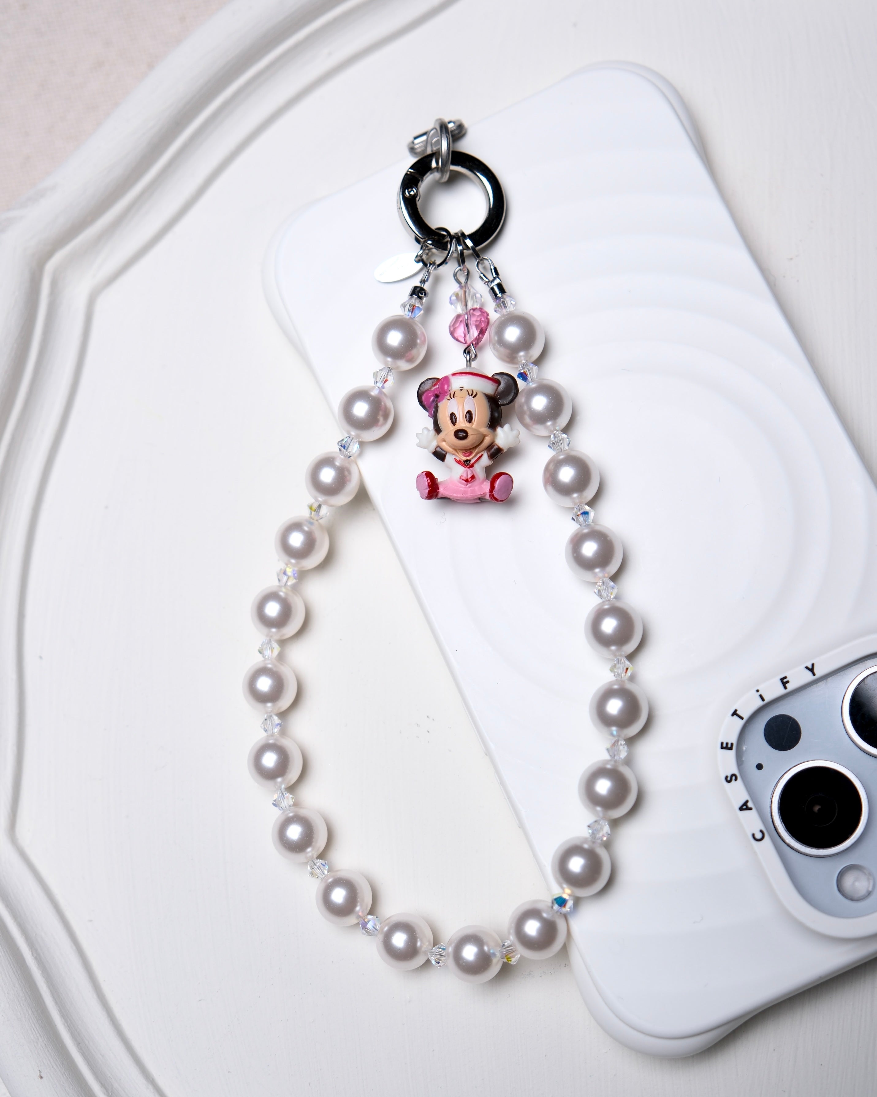 Detail product photo of a Swarovski pearl and crystal phone chain with silver-tone phone hardware.