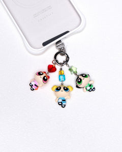 Product photo of a vintage trio character phone charm with colorful Swarovski crystal accents.