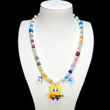 Additional product photo of a rainbow crystal and pearl guitar charm necklace with blue crystal star accents.