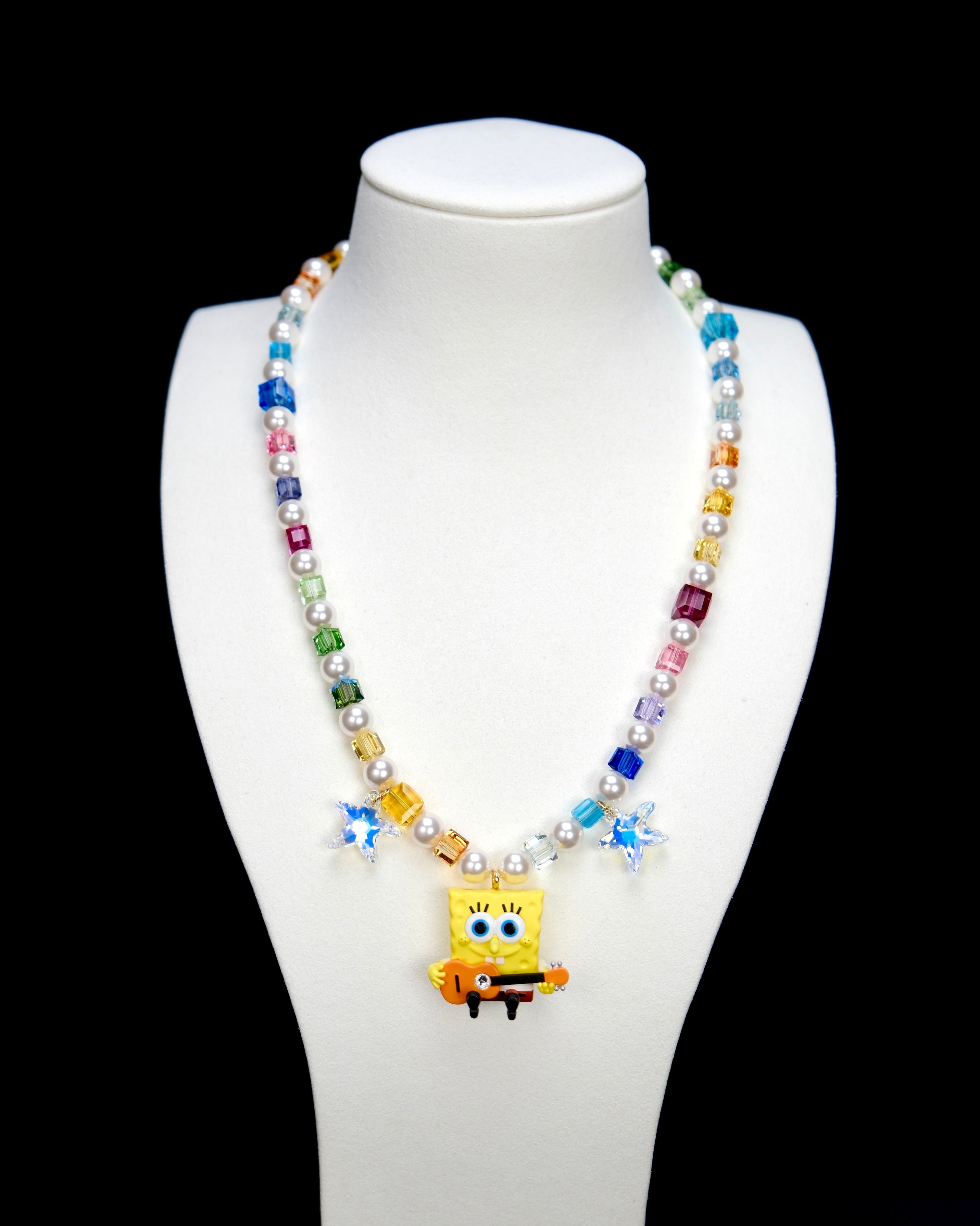 Additional product photo of a rainbow crystal and pearl guitar charm necklace with blue crystal star accents.
