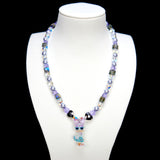 Detail product photo of a lavender and blue duck charm necklace with pearl and iridescent crystal beads.