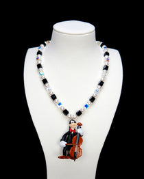 Product photo of a cello-player vintage charm necklace with Swarovski crystals and pearls.