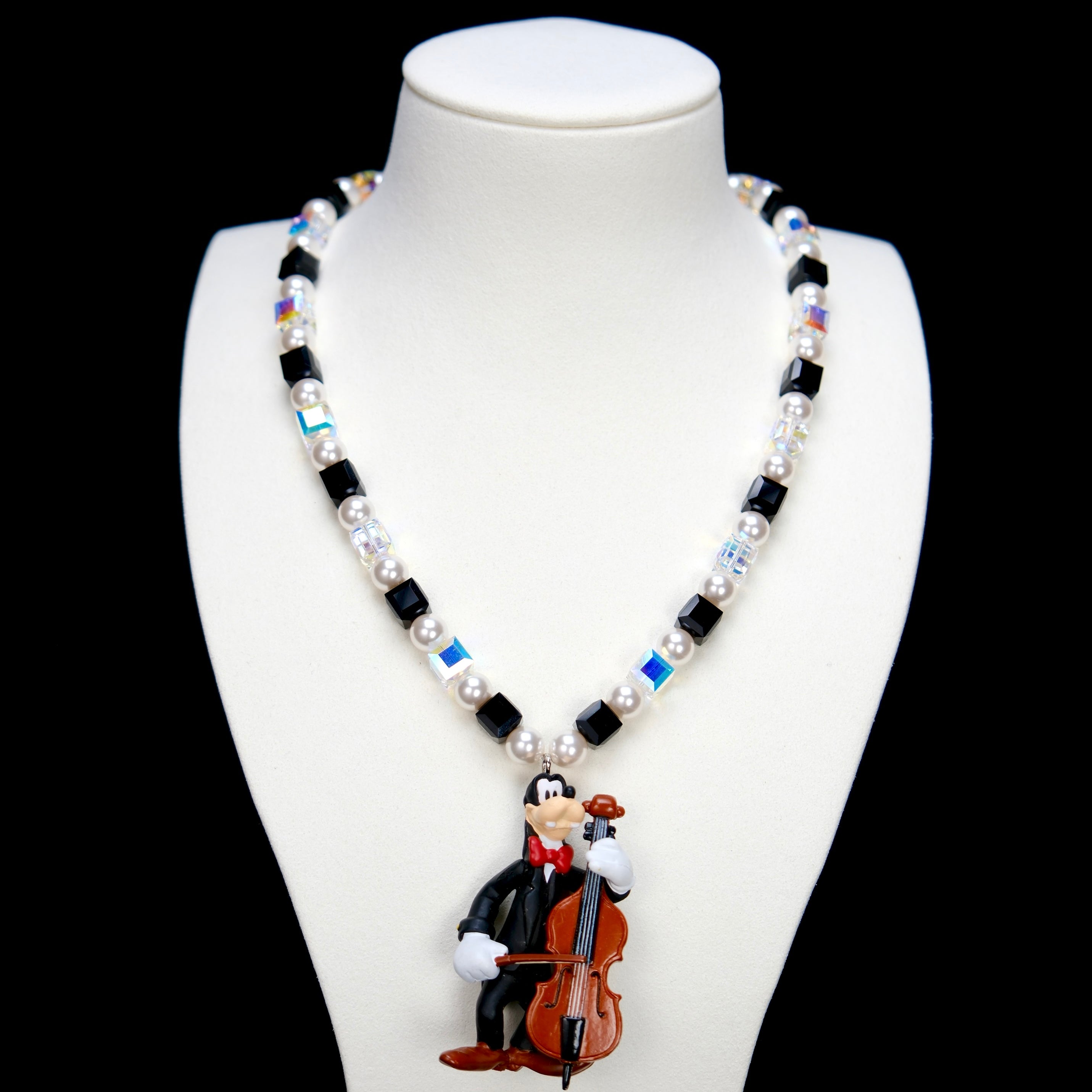 Product photo of a cello-player vintage charm necklace with Swarovski crystals and pearls.