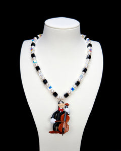 Product photo of a cello-player vintage charm necklace with Swarovski crystals and pearls.