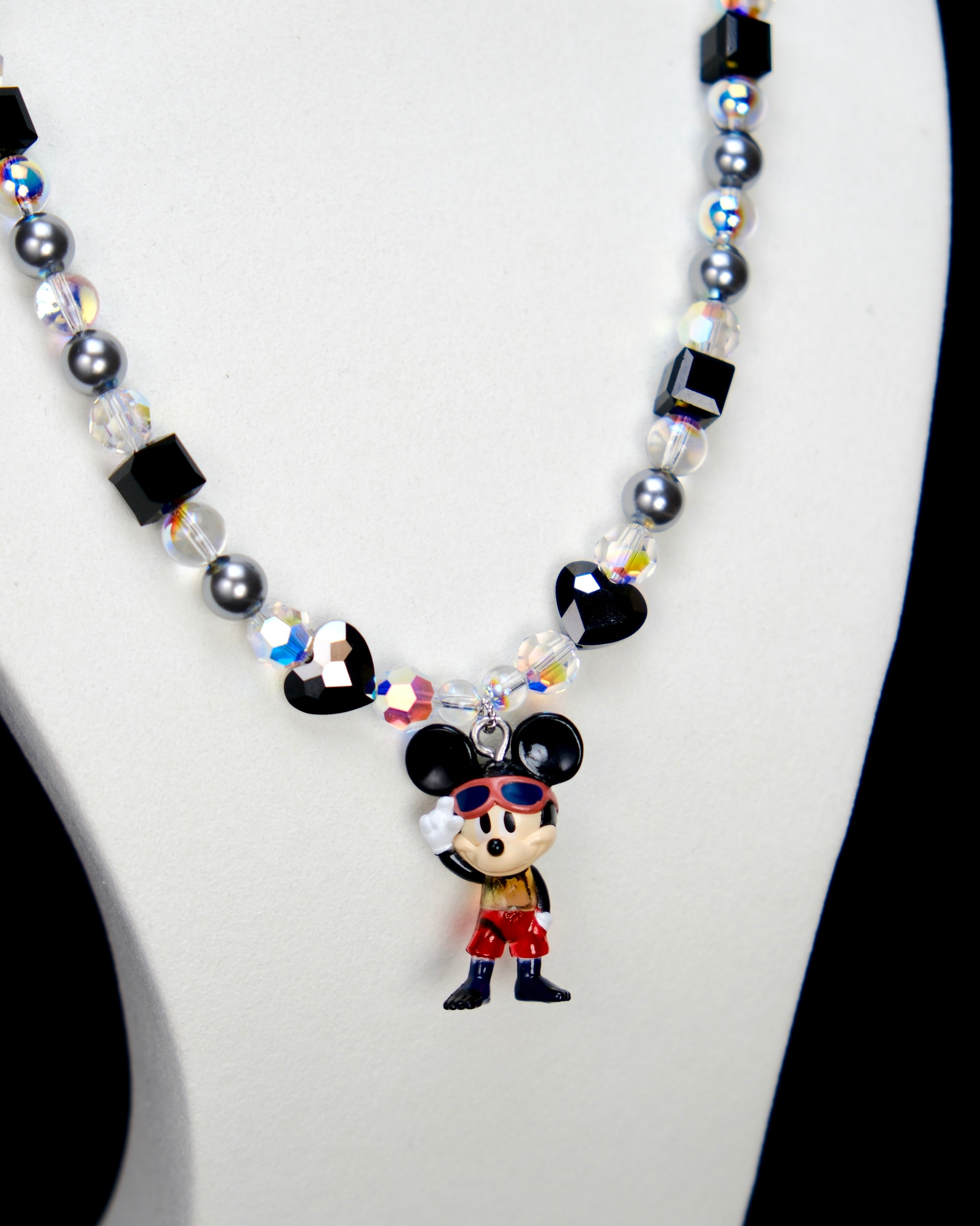 Alternate product photo of a black and silver mouse charm necklace with gray pearls and black crystal beads.
