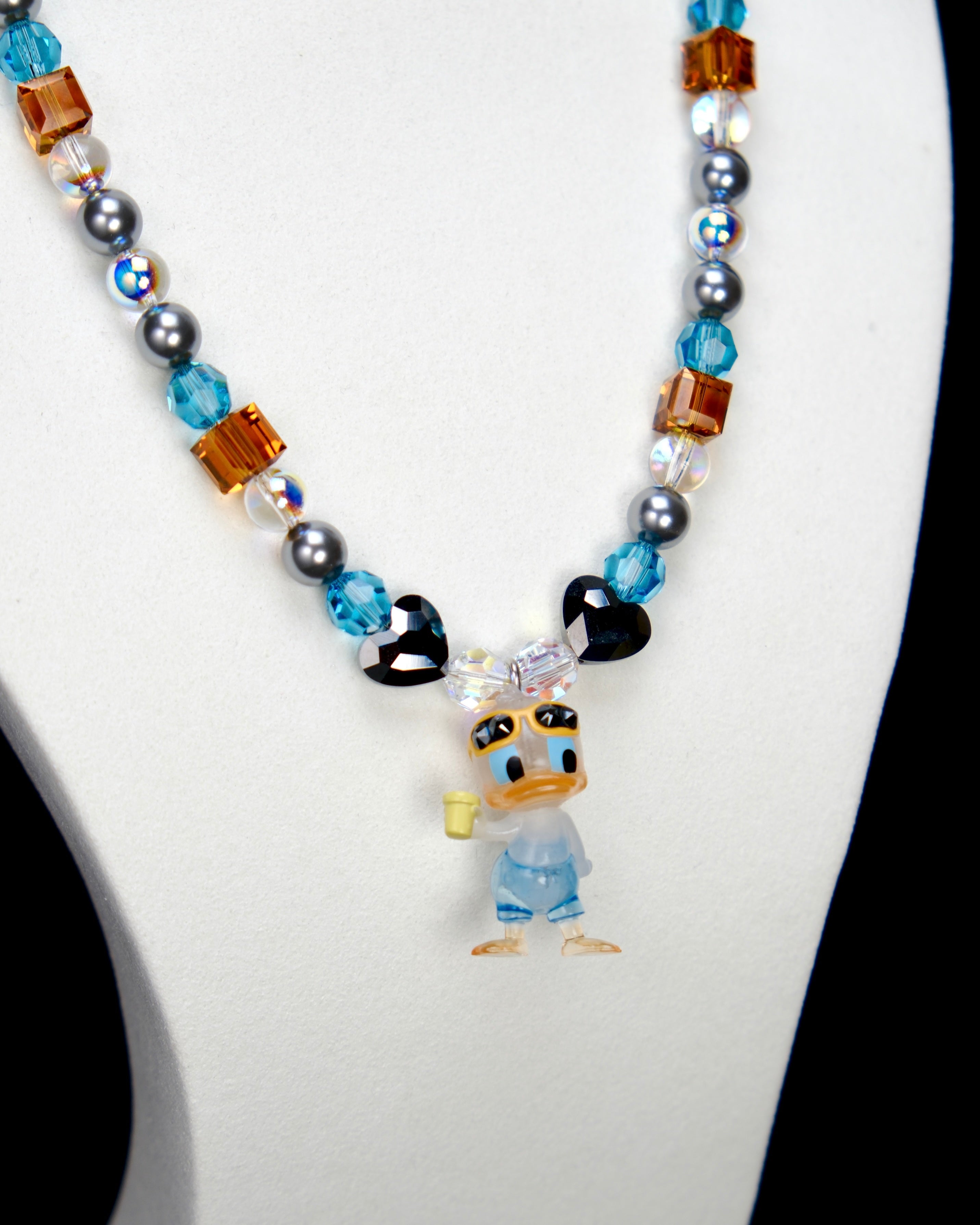 Alternate product photo of an orange and blue duck charm necklace with gray pearls and faceted crystal beads.
