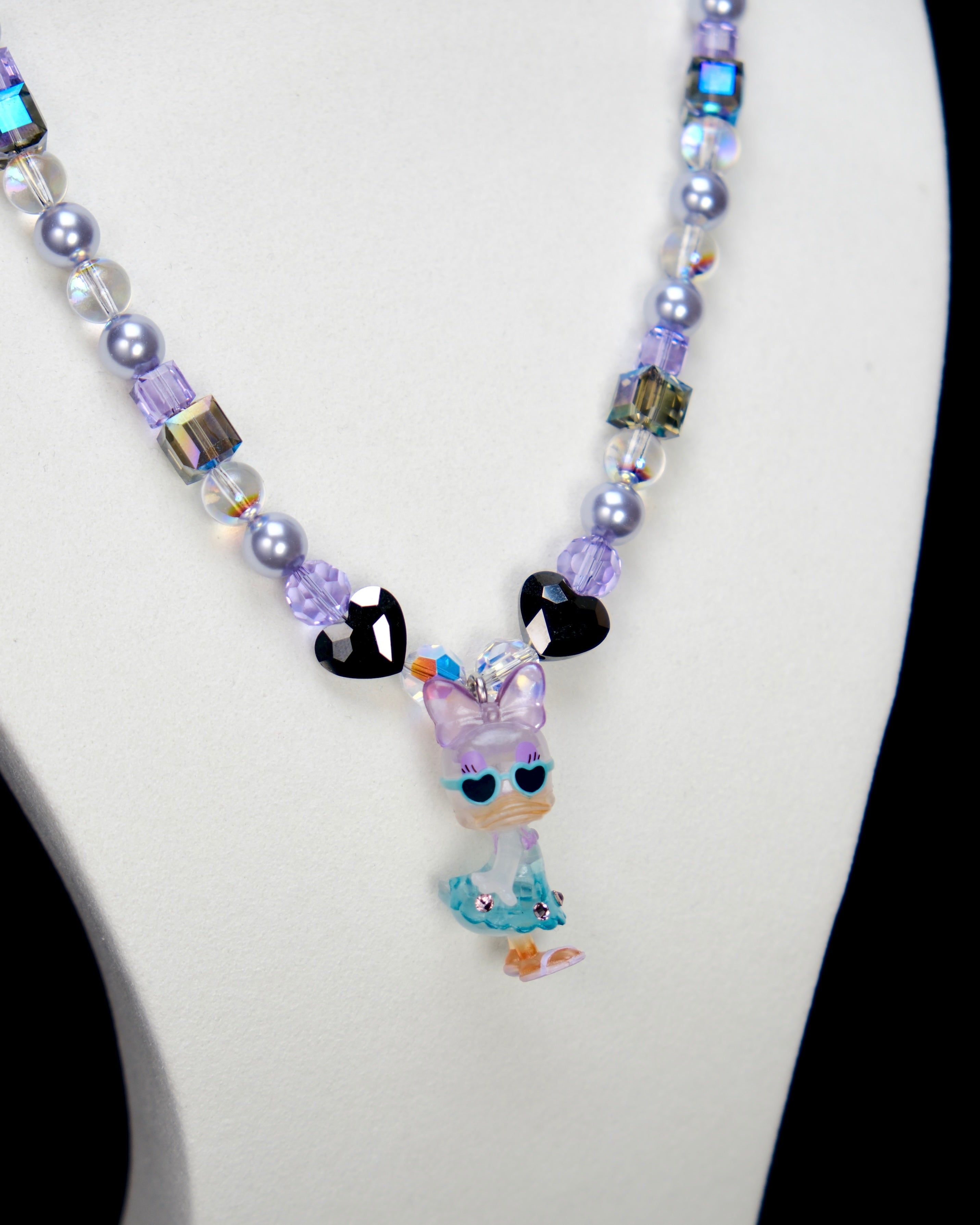 Alternate product photo of a lavender and blue duck charm necklace with pearl and iridescent crystal beads.