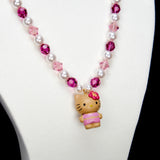 Alternate product photo of a pink pearl cat charm necklace with white pearls, pink crystals, and gold-tone hardware.