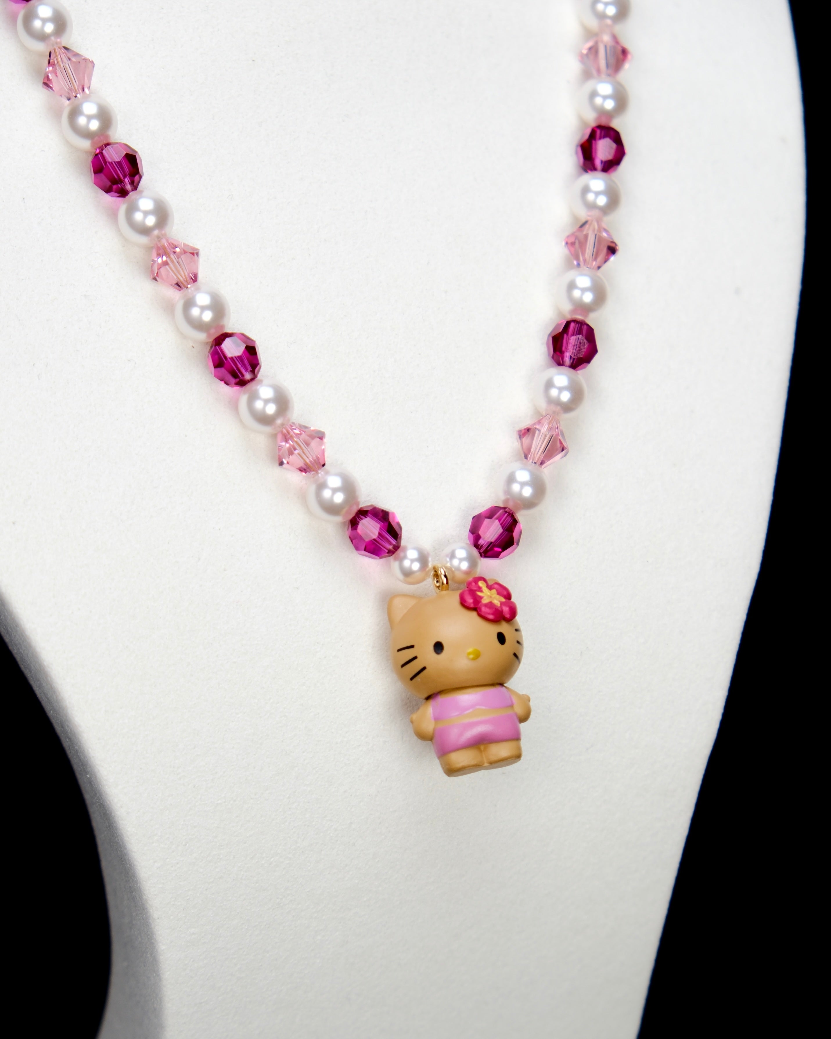 Alternate product photo of a pink pearl cat charm necklace with white pearls, pink crystals, and gold-tone hardware.