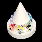 Detail product photo of a rainbow crystal charm bracelet with three vintage heroine character charms.