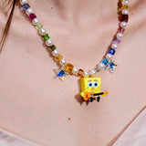 Product photo of a rainbow crystal and pearl guitar charm necklace with blue crystal star accents.