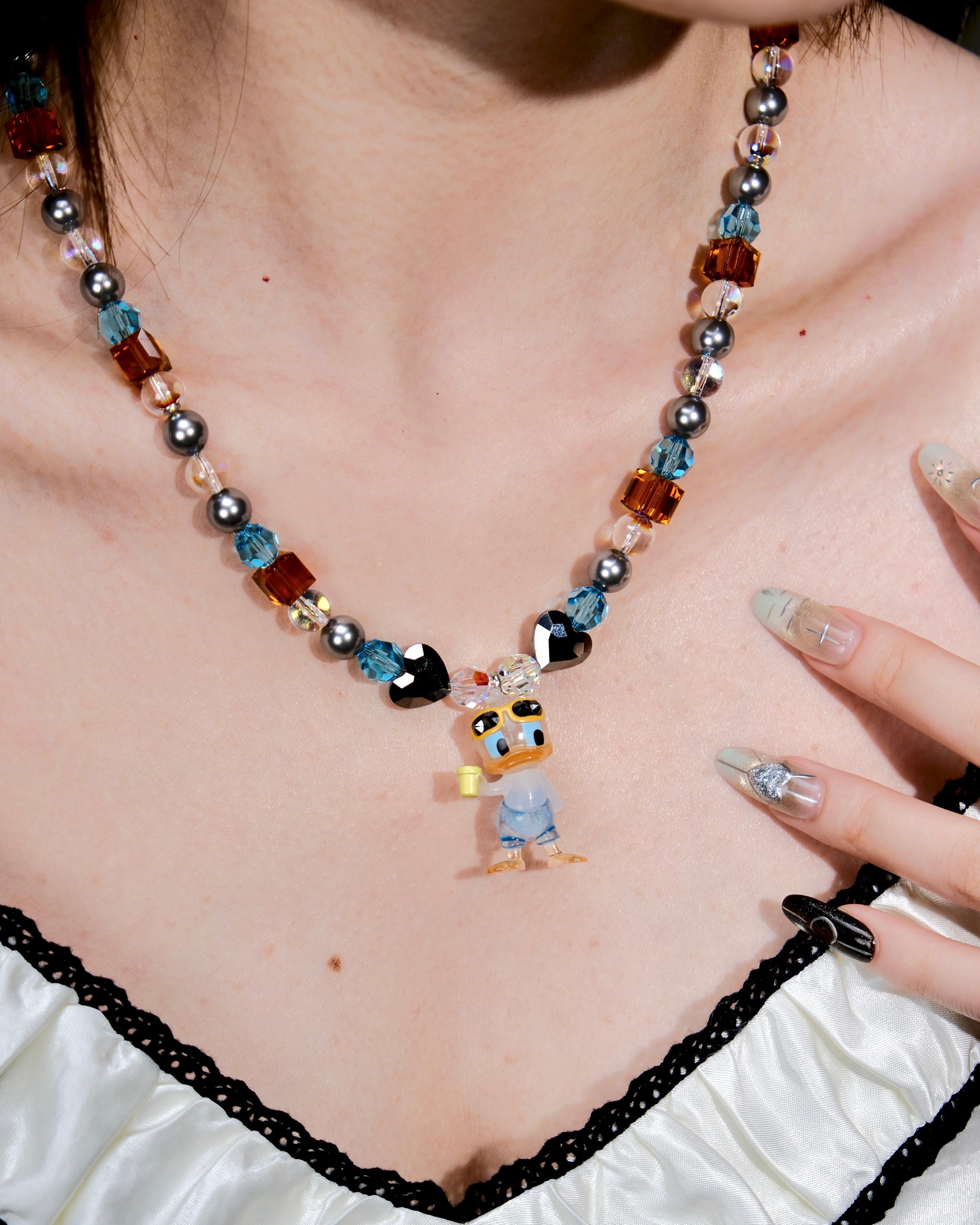 Additional product photo of an orange and blue duck charm necklace with gray pearls and faceted crystal beads.