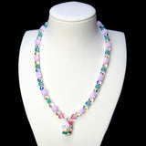 Front studio product view of Lilac Bloom Crystal Charm Necklace on a white jewelry display against a black background.