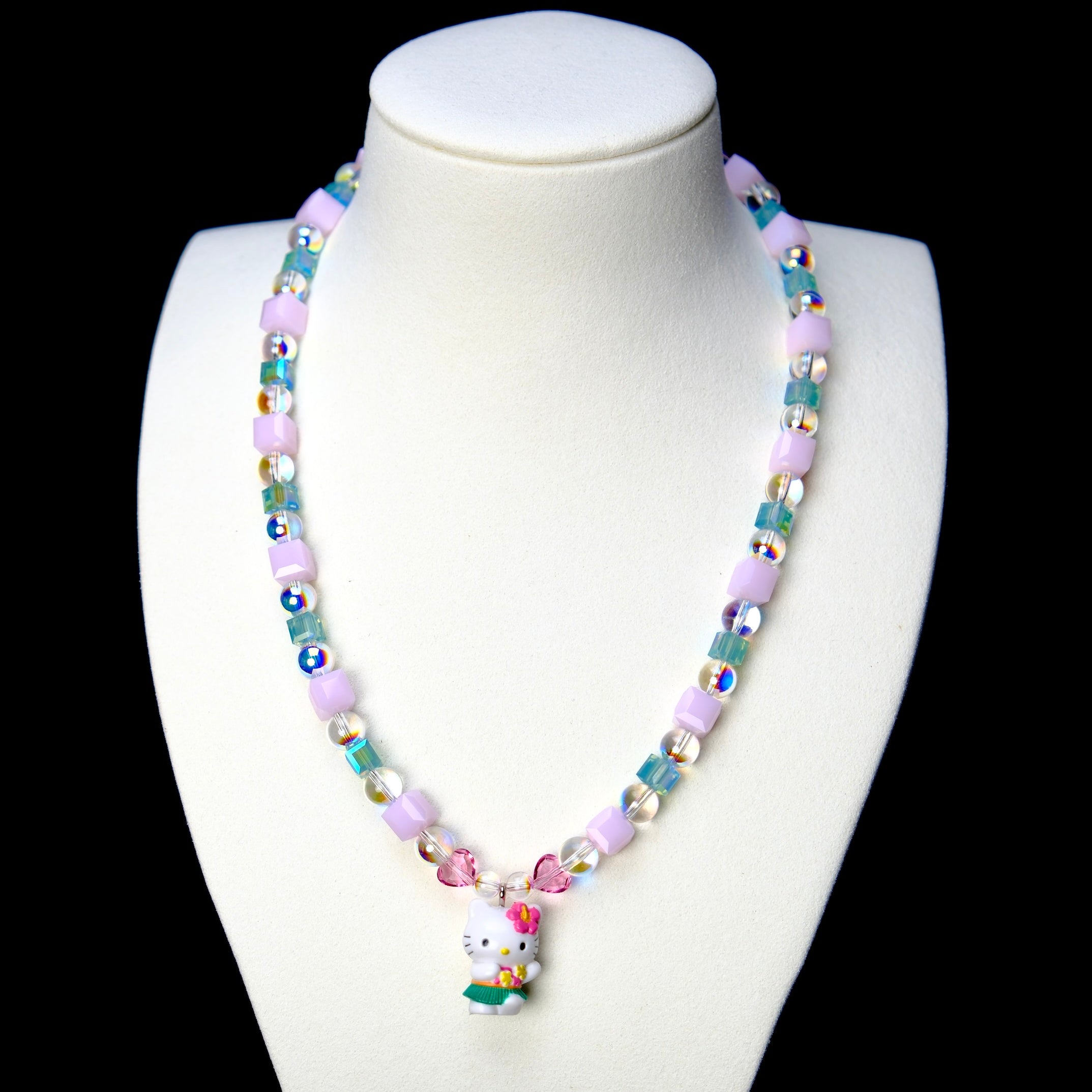 Front studio product view of Lilac Bloom Crystal Charm Necklace on a white jewelry display against a black background.
