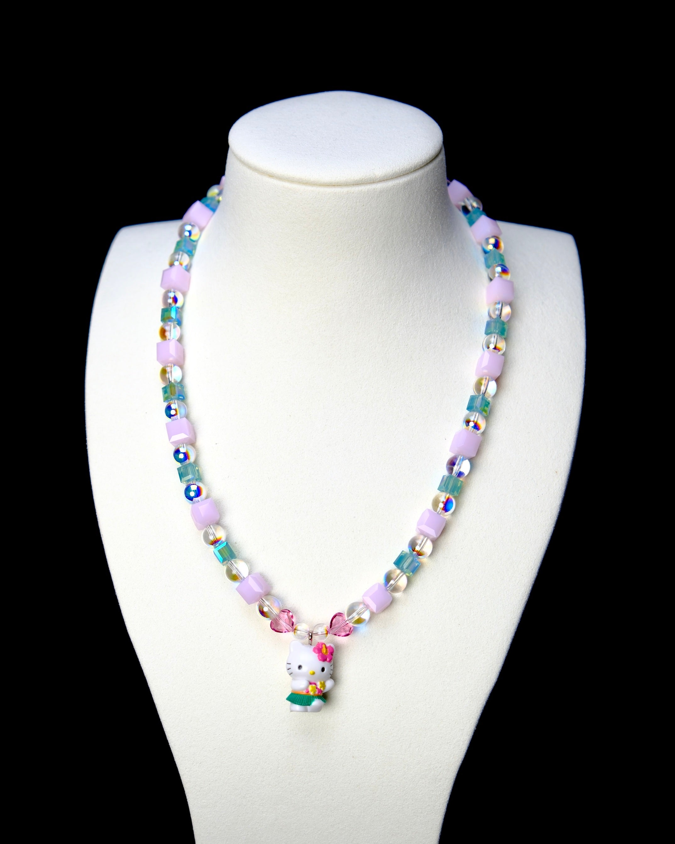 Front studio product view of Lilac Bloom Crystal Charm Necklace on a white jewelry display against a black background.
