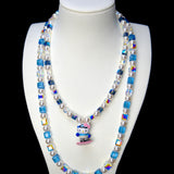 Front studio product view of Blue Glide Double Layer Crystal Necklace on a white jewelry display against a black background.
