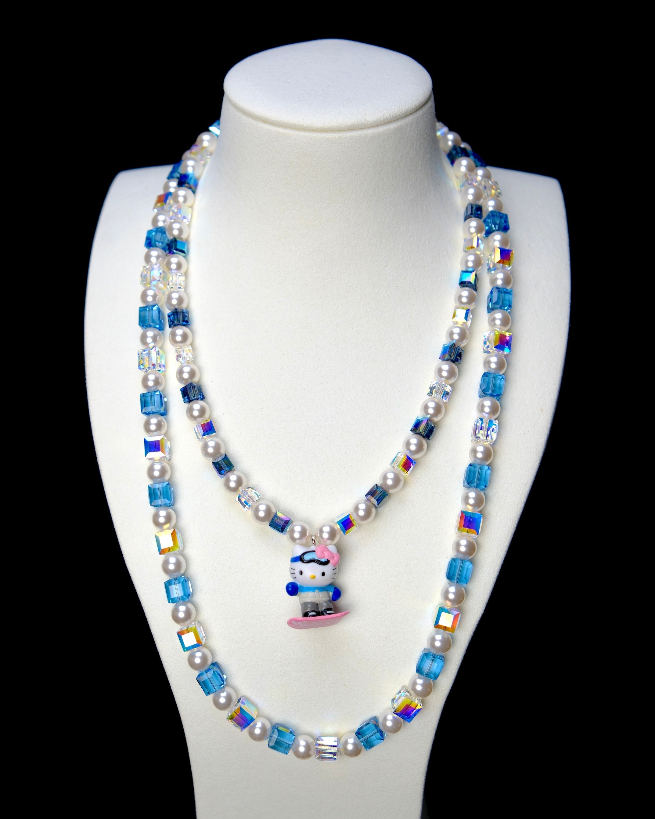 Front studio product view of Blue Glide Double Layer Crystal Necklace on a white jewelry display against a black background.