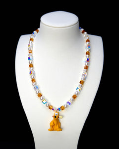 Front studio product view of Amber Daydream Crystal Charm Necklace on a white jewelry display against a black background.