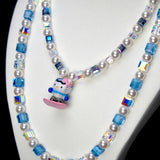 Angled studio product view of Blue Glide Double Layer Crystal Necklace on a white jewelry display against a black background.