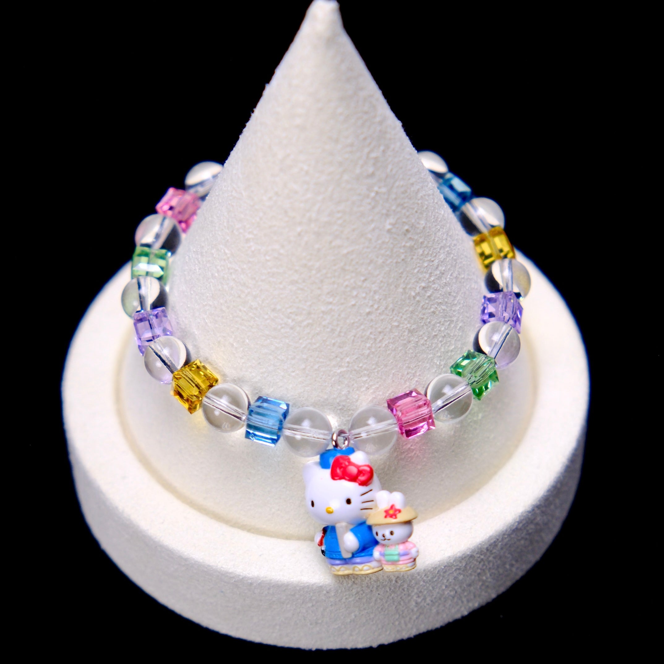 Front studio product view of Rainbow Friends Crystal Charm Bracelet on a white jewelry display against a black background.