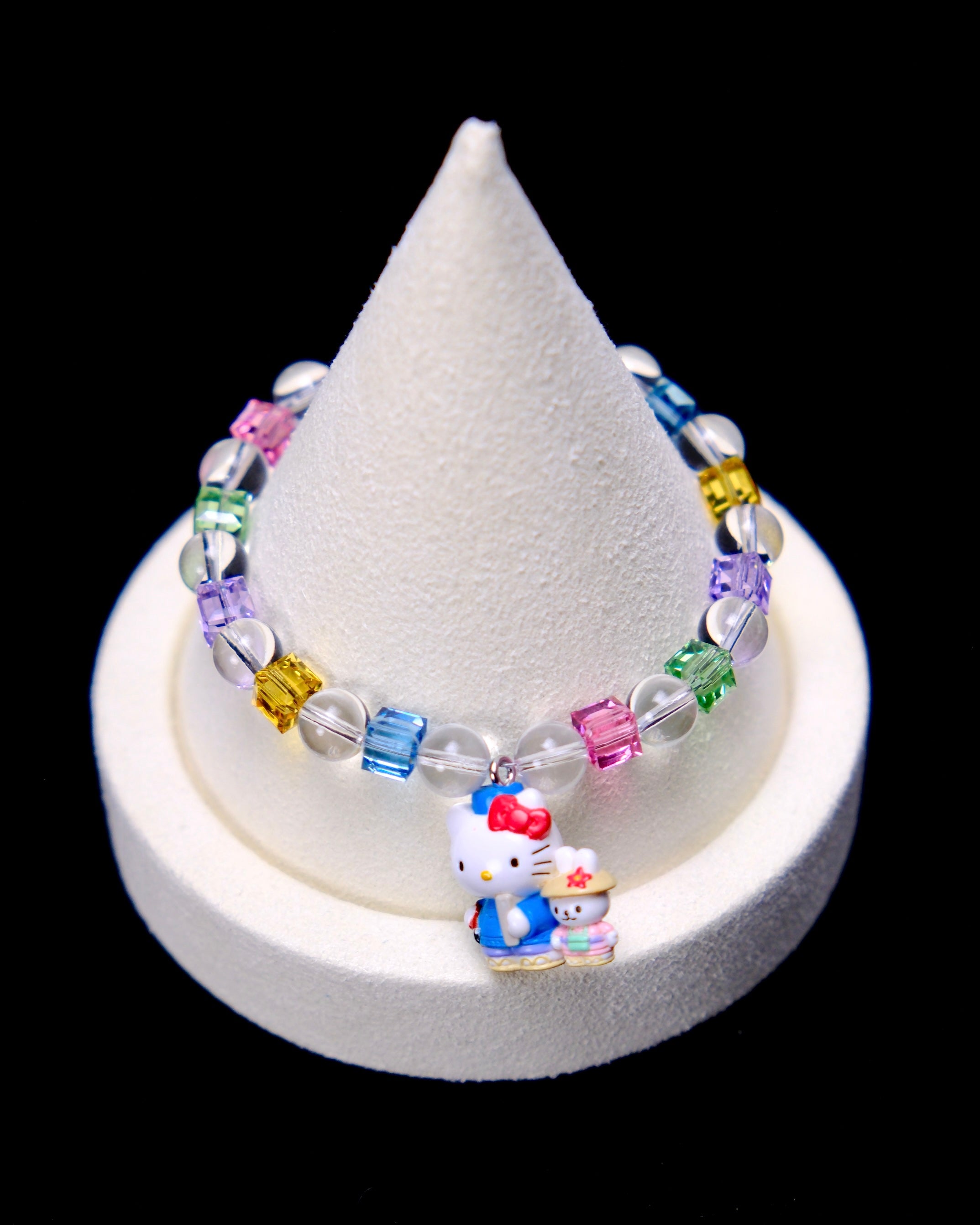 Front studio product view of Rainbow Friends Crystal Charm Bracelet on a white jewelry display against a black background.