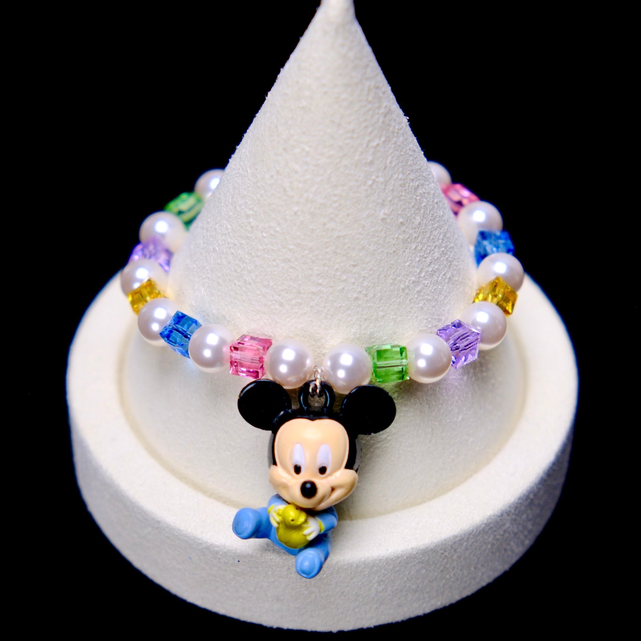 Front studio product view of Rainbow Keepsake Crystal Charm Bracelet on a white jewelry display against a black background.
