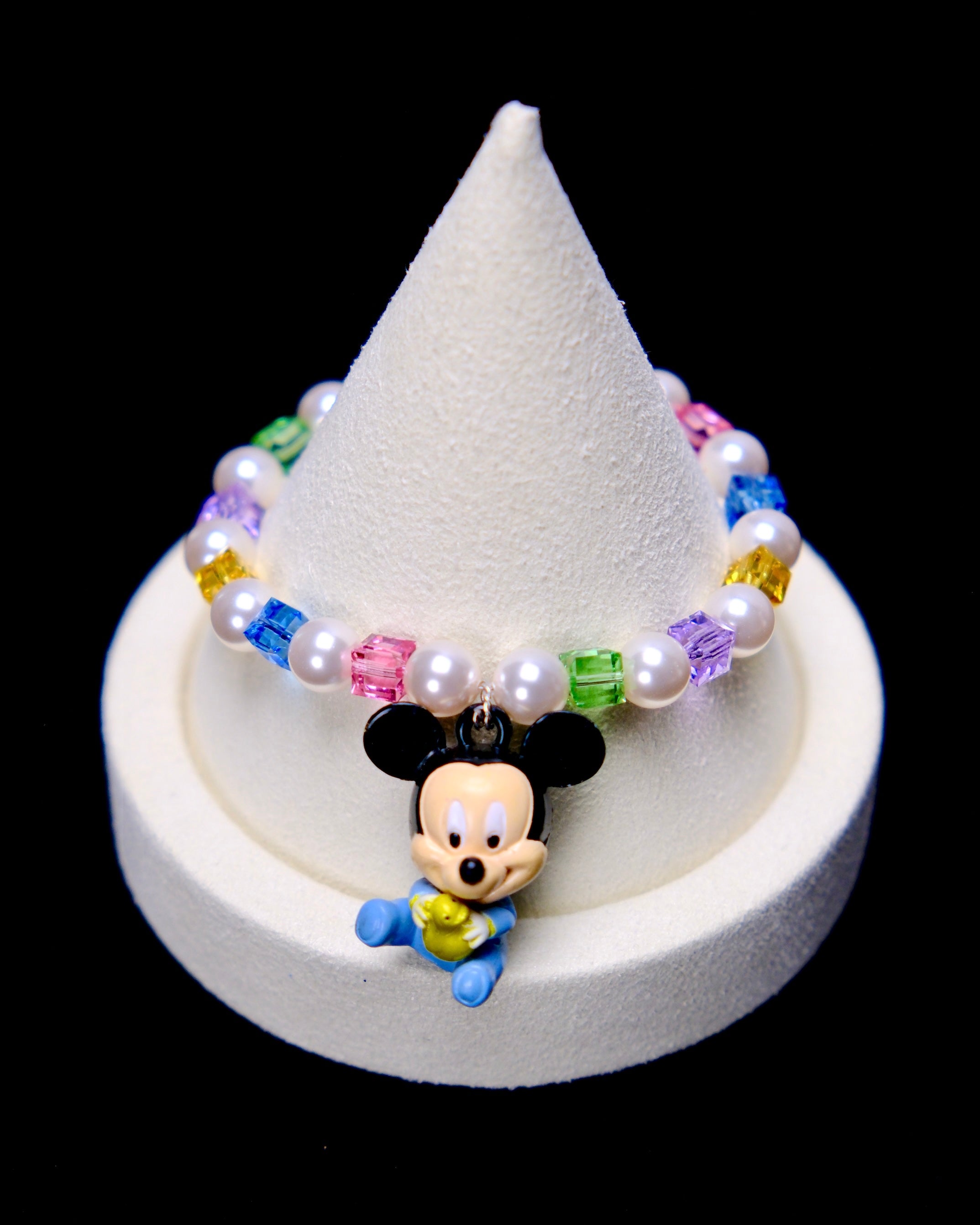 Front studio product view of Rainbow Keepsake Crystal Charm Bracelet on a white jewelry display against a black background.