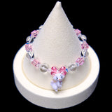 Front studio product view of Pink Bow Crystal Charm Bracelet on a white jewelry display against a black background.