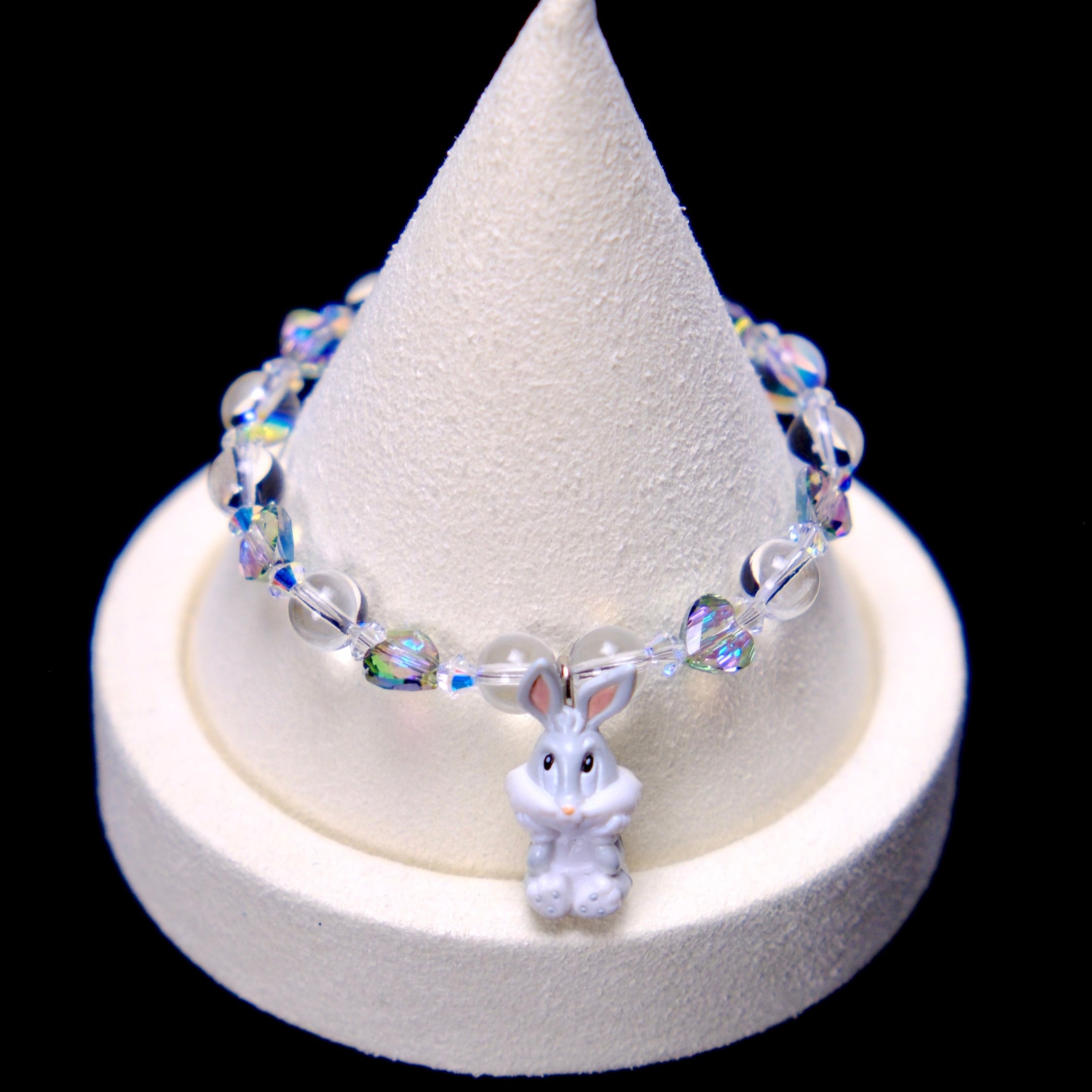 Front studio product view of Iridescent Bunny Crystal Charm Bracelet on a white jewelry display against a black background.