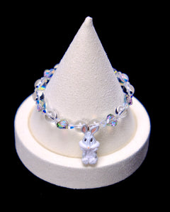 Front studio product view of Iridescent Bunny Crystal Charm Bracelet on a white jewelry display against a black background.