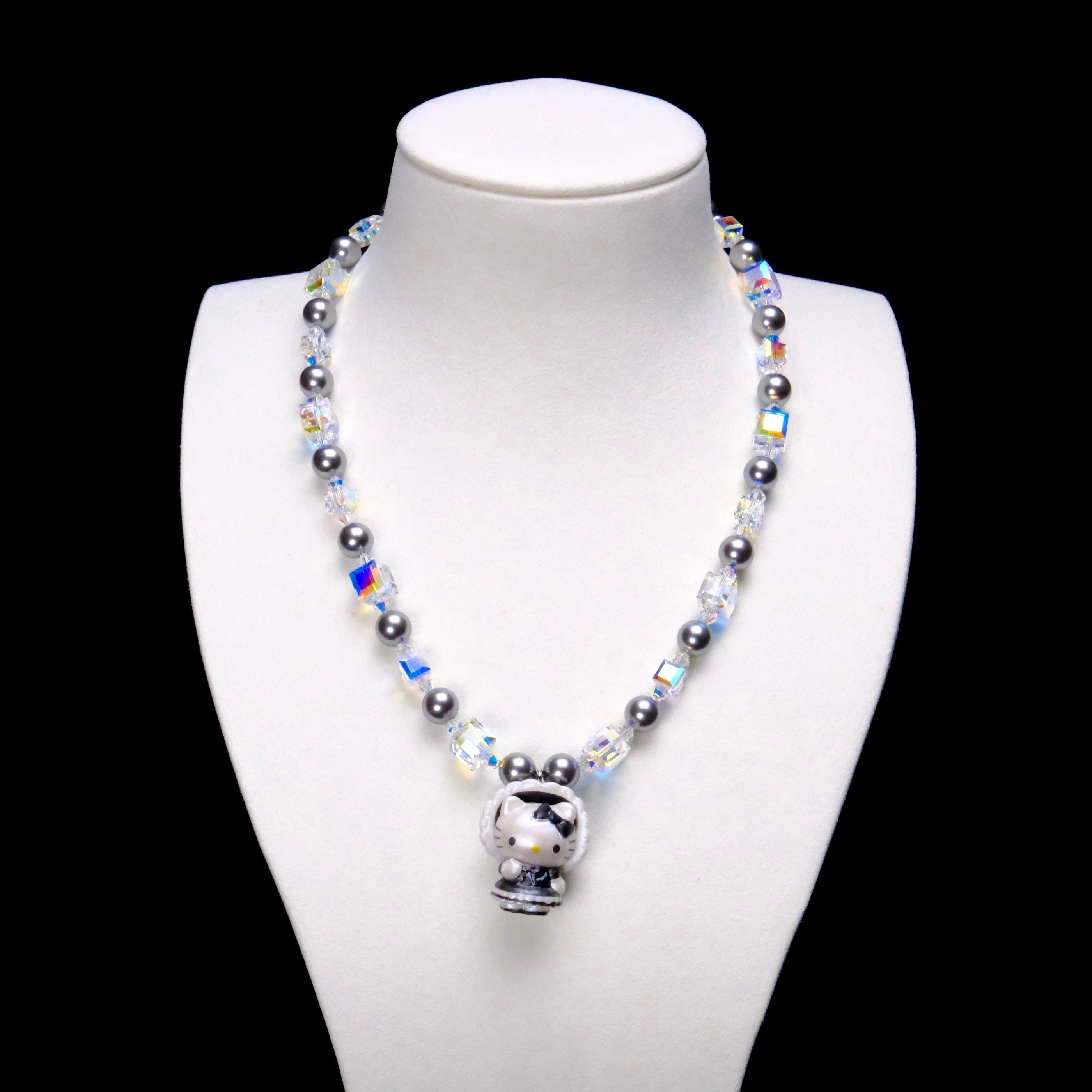 Midnight Bonnet Cat Charm Necklace with gray pearls, iridescent crystal cubes and a bonnet cat pendant on a white bust.