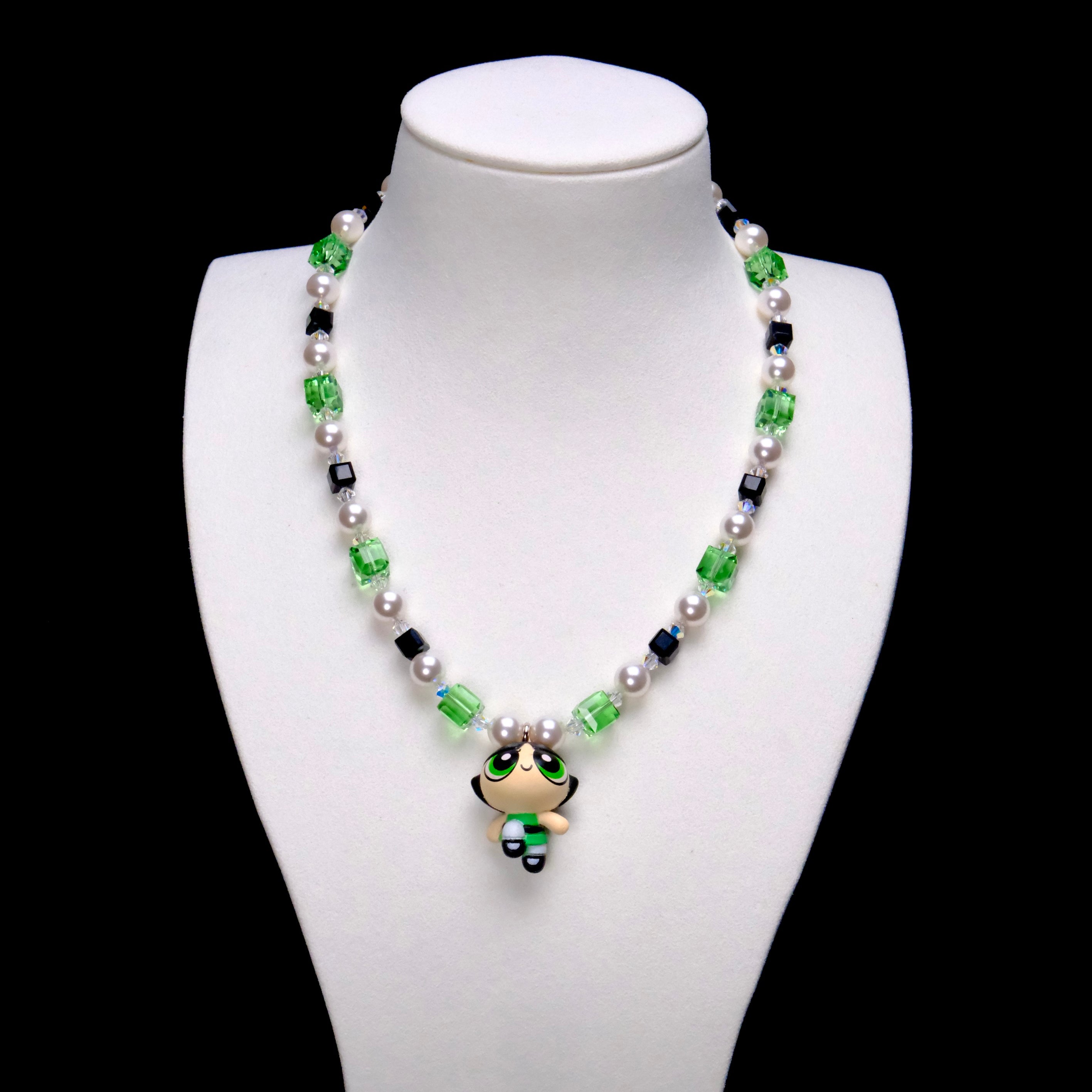 Green Force Charm Necklace with green and black crystal cubes, white pearls and a green-outfit girl pendant on a white bust.