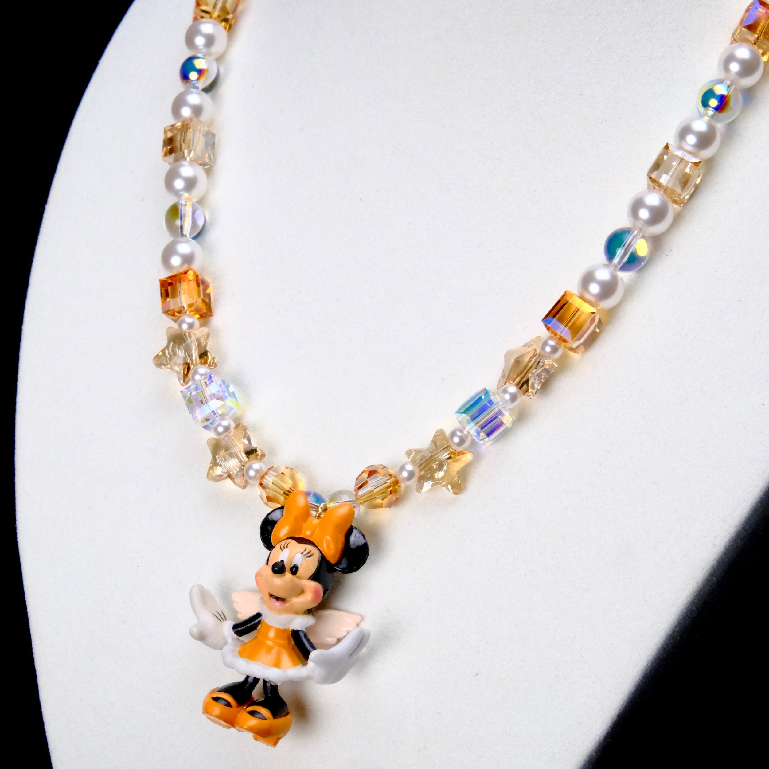 Angled close-up of Amber Starlight Mouse Charm Necklace showing amber crystal cubes, white pearls, star beads and a mouse pendant.