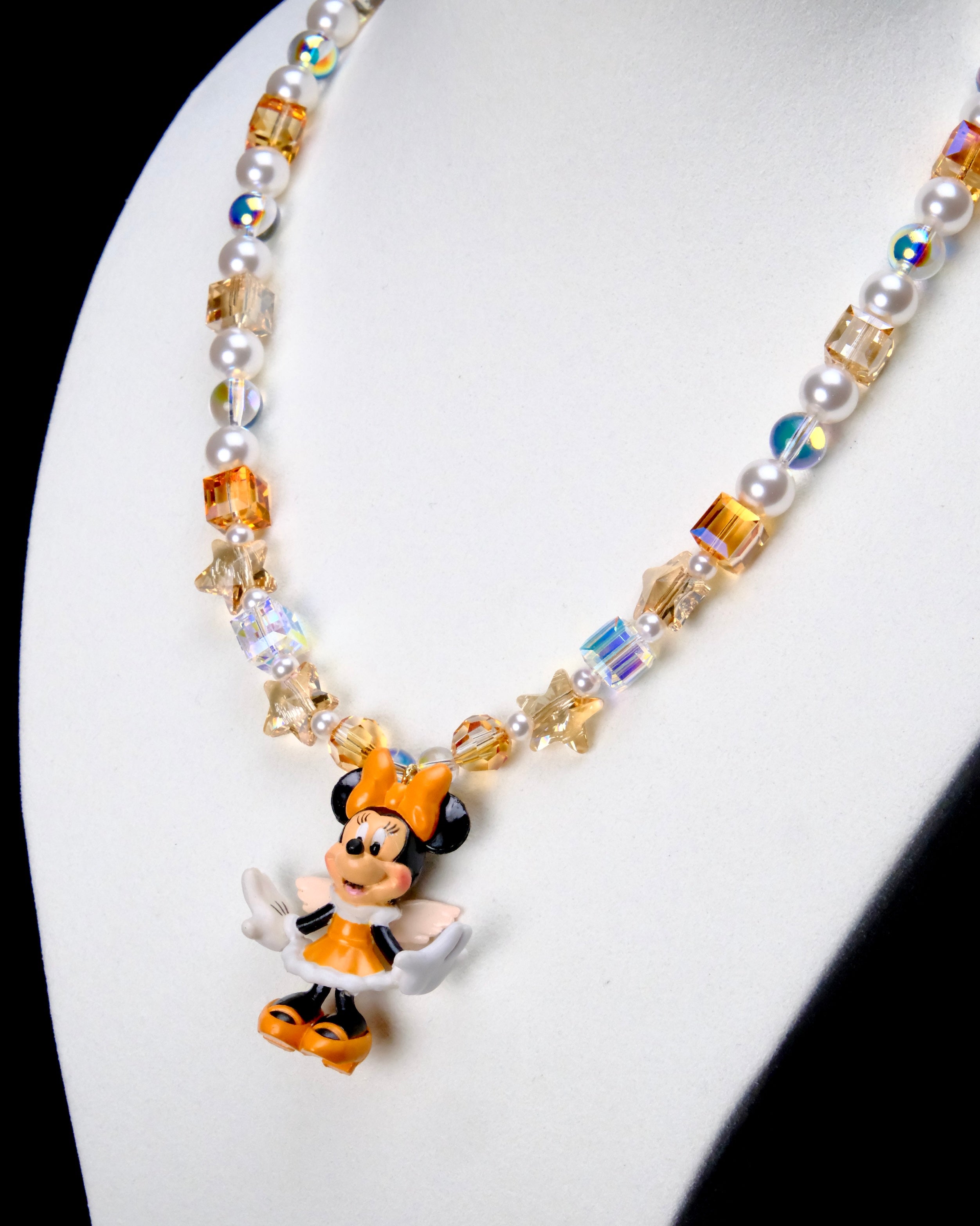 Angled close-up of Amber Starlight Mouse Charm Necklace showing amber crystal cubes, white pearls, star beads and a mouse pendant.