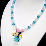 Angled close-up of Aqua Star Wishes Charm Necklace showing aqua crystals, star beads and a pink-bow mouse holding a yellow star.