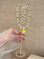 Green and yellow Swarovski crystal beads close-up on handmade pearl charm necklace - beaded jewelry