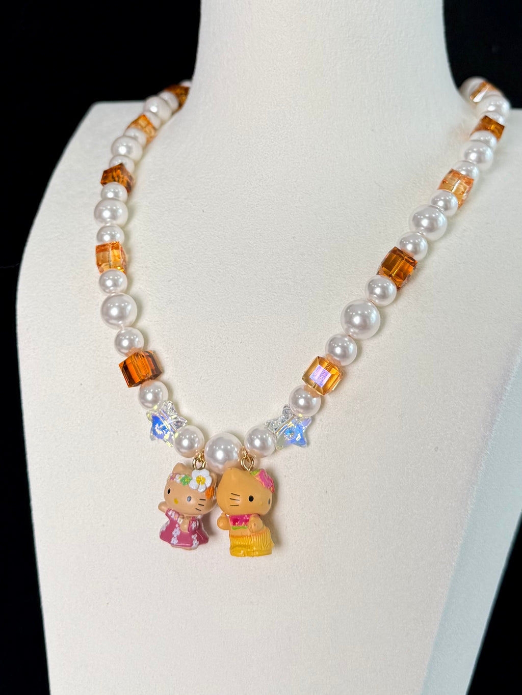 Swarovski crystal beads and pearls close-up on handmade amber charm necklace by ShinoraStudio