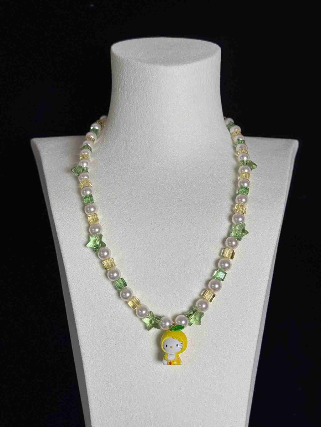 Model wearing handmade green crystal charm necklace with yellow Swarovski beads and pearls