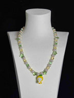 Model wearing handmade green crystal charm necklace with yellow Swarovski beads and pearls