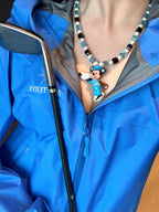 Vintage charm pendant close-up on handmade blue Swarovski crystal and pearl necklace