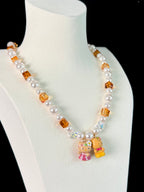 Model wearing handmade amber crystal charm necklace with white Swarovski beads and pearls